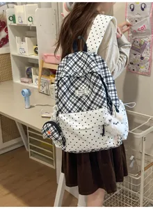 Vue arrière d’un sac à dos porté, motifs à carreaux et à pois noirs et blancs, avec petite pochette