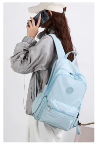 Seitenansicht eines Models mit hellblauem Rucksack, Reißverschlussfächern und passenden Gurten