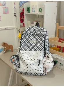 Vue d’un sac à dos à carreaux noirs et blancs et à pois, avec pochette assortie et breloque lapin