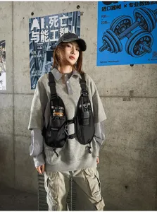 Street-style view of a model wearing a black chest bag with adjustable straps and front buckles