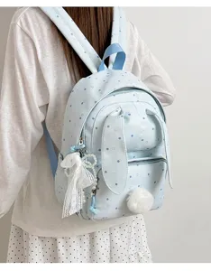 Sac à dos bleu clair à pois et oreilles de lapin, porté avec poche zippée et pompon doux