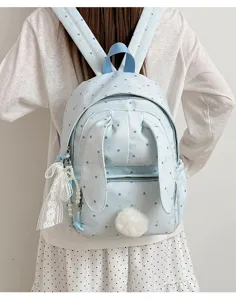 Vue de dos avec un sac bleu clair à pois, oreilles de lapin, pompon et breloques en dentelle