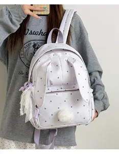 Sac à dos lavande à pois avec oreilles de lapin, pompon et breloques en dentelle, porté par un modèle