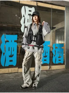 Street-style view of a person wearing a black chest vest with front pockets and adjustable straps