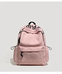 Vue de face d’un sac rose avec motifs en relief, lettrage noir, poche zippée et cordons latéraux
