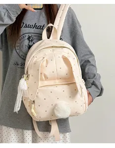 Sac crème à pois bruns, oreilles de lapin, pompon doux et pampille en dentelle porté par un modèle