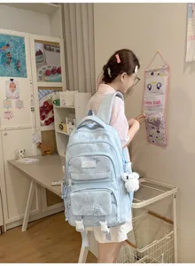 Élève portant un sac bleu clair à étoiles avec un ours en peluche dans une chambre d'étude