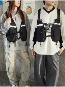 Two models wear black vest-style chest bags with reflective strips, adjustable straps and pockets.