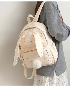 Vue de dos d’une personne portant un sac crème à pois, avec oreilles de lapin et pompon doux