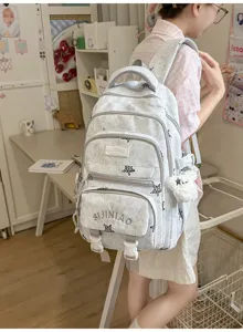 Vue arrière d'une élève avec un sac à dos clair à motifs, poches zippées et pendentif en peluche