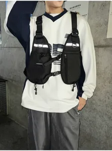 Model wearing a black chest-rig bag with twin zip pockets, adjustable straps and metal buckles