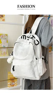 Sac à dos blanc porté par un modèle, avec reliefs étoilés, lettrage noir et charm en peluche