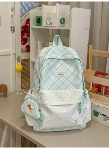 Vue de face avec carreaux bleu clair, pois blancs, pochette assortie et écusson lapin.