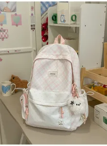 Carreaux roses, poche avant à pois, broderie de lapin et pendentif blanc en peluche en intérieur
