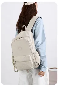 Model mit hellbeigem Nylonrucksack, sichtbar sind Reißverschlussfach vorn und Seitentasche