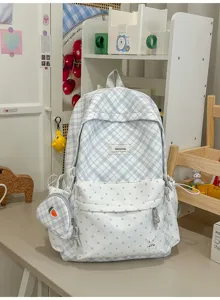 Carreaux bleus et blancs à pois, avec pochette carotte et breloque lapin, sur un bureau