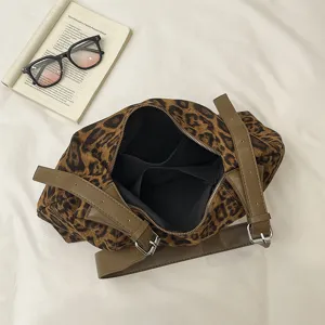 Sac léopard porté épaule pour femme, brides brunes, bouclerie métal et zip ouvert