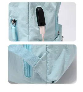 Nahaufnahme von USB-Anschluss, Reißverschluss und vernähtem Gurt am hellblauen Rucksack