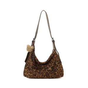 Sac à épaule en suédine à motif léopard, avec une bandoulière brune et un charm ours en peluche