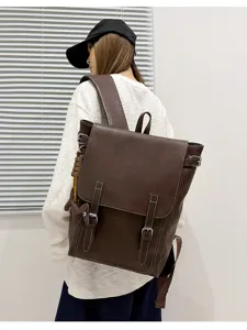 Rückansicht eines Models mit braunem Rucksack aus Kunstleder, Überschlag und Metallschnallen.
