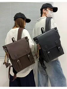 Rückansicht zweier Models mit braunen und schwarzen Rucksäcken mit Klappe, Schnallen und Anhängern