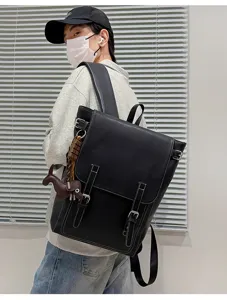 Seitenansicht eines Models mit schwarzem Kunstlederrucksack, Klappe, Schnallenriemen, Nähten und Anhänger