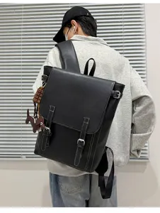 Rückansicht einer Person mit schwarzem Rucksack mit Klappe, Metallschnallen und Kontrastnähten