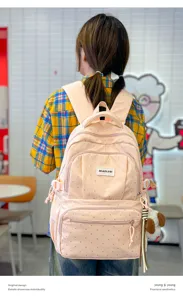 Vue de dos : sac à dos rose à pois, poches zippées et petit pendentif chien en peluche