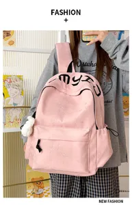 Sac à dos rose à étoiles en relief porté par un modèle, avec poche avant et pompon blanc.