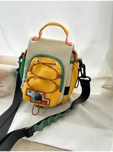 Détail du sac multicolore avec poche jaune à cordon, écusson HAPPY et sangle tissée réglable