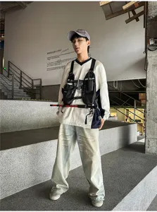 Streetwear outfit showing a black tactical chest bag worn over a color-block V-neck sweatshirt