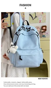 Détail du sac à dos bleu clair, étoiles en relief, poche avant zippée et lapin en peluche