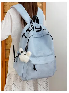 Sac bleu clair, étoiles et empreintes en relief, lettrage noir et petit ours en peluche suspendu