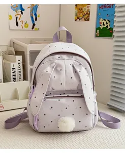 Vue de face d’un sac à dos lilas à pois, avec oreilles de lapin et pompon doux décoratif