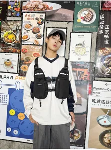 Front view of a black chest pack worn over a shirt, showing zip pockets and adjustable straps