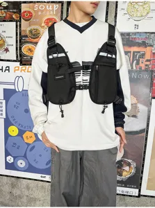 Front view of a model wearing a black multi-pocket chest rig with adjustable straps and buckles