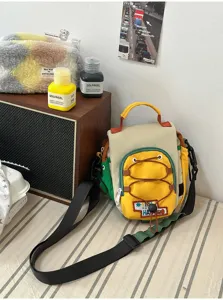 Vue de face de la poche jaune à cordon, des panneaux colorés et de la sangle noire réglable