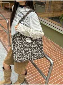 Outdoor view of a woman carrying a leopard-print tote with a soft surface and white label