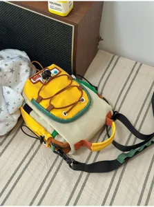 Vue rapprochée d'un sac jaune et crème avec bordure verte, détail à cordon et bandoulière réglable