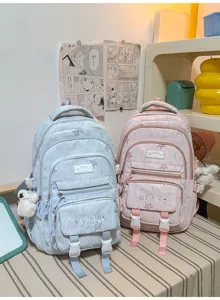 Deux sacs à dos bleu et rose côte à côte, avec écussons brodés et plusieurs poches avant