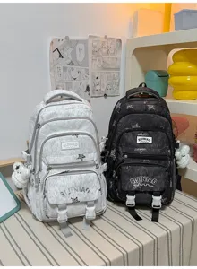 Deux sacs à dos en tissu côte à côte, gris clair et noir, avec étoiles et breloques en peluche