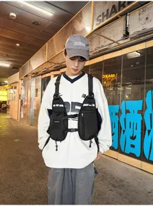 Front view of a black nylon chest rig with adjustable straps, buckles and zippered pockets