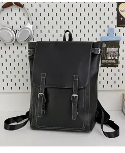 Vorderansicht eines schwarzen Kunstlederrucksacks mit Doppelschnallen und weißen Ziernähten
