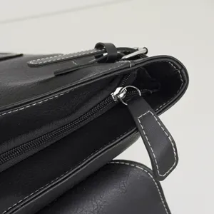Schwarzer Kunstleder-Laptoprucksack, Nahaufnahme mit weißen Nähten und silbernem Reißverschluss