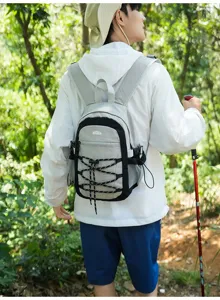 Wanderin mit grau-weißem Rucksack, schwarzer Einfassung und elastischer Frontschnürung im Wald
