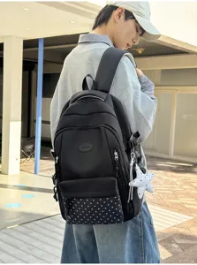 Vue extérieure d’une personne portant un sac à dos noir, poche étoilée et breloque étoile pendante