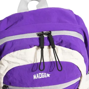 Leichter Nylon-Wanderrucksack in Lila und Creme, Nahaufnahme mit Reißverschlüssen am Vorderfach