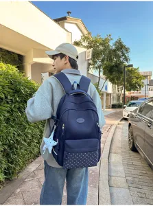 Vue de dos avec sac à dos bleu marine, panneau inférieur à étoiles et breloque en forme d’étoile