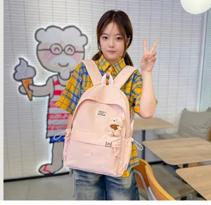 Modèle portant un sac rose pâle, avec broderies d’étoiles et un petit pendentif ourson, de face