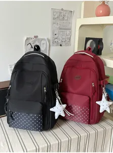 Deux sacs à dos noir et bordeaux côte à côte, avec poches à étoiles et breloques décoratives